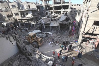 Penduduk Palestin yang kehilangan tempat tinggal berkumpul di lokasi sebuah bangunan rosak yang menjadi sasaran serangan Israel di kem pelarian Maghazi, tengah Semenanjung Gaza. Foto AFP