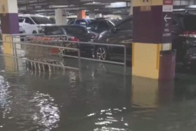 Tangkap layar video yang dimuat naik orang ramai mengenai kawasan tempat letak kereta sebuah pusat beli-belah di Putrajaya dinaiki air susulan hujan lebat berterusan pada Sabtu.