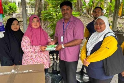Nor Atheerah (kiri) bersama ibunya, Masjida Yanti Nasution Abdullah Omar, 51, ketika menerima kunjungan pengurusan cawangan Mydin Meru Raya pada Sabtu.