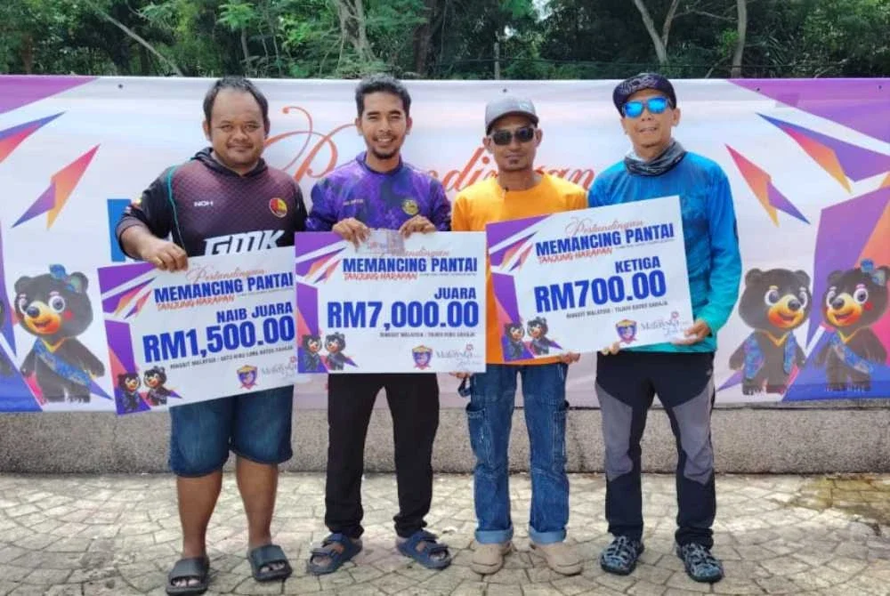 Syahfizam (kanan) bersama pemenang pertandingan memancing di Pantai Tanjung Harapan.