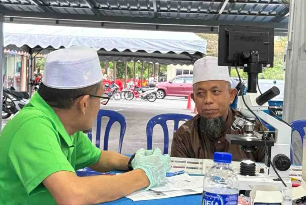 Sesi saringan darah dan analisis kesihatan oleh Ustaz Salleh (kiri) bagi membantu jemaah memahami keadaan kesihatan mereka dengan lebih tepat.