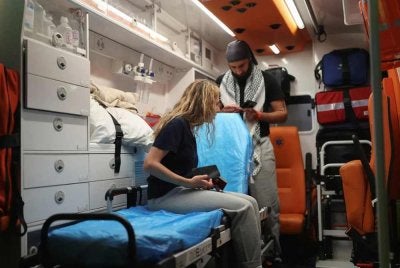 Seorang aktivis Greece yang ditahan oleh pasukan Israel duduk di atas pengusung dalam sebuah ambulans sebaik tiba di Lapangan Terbang Antarabangsa Eleftherios Venizelos, Greece. - FOTO: Reuters 
