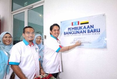 Mohamad Hairul Amir menandatangani plak sebagai gimik pembukaan rasmi pejabat operasi baharu PKR Perak di Wisma Keadilan Negeri Perak di Meru Raya, Ipoh pada Sabtu.