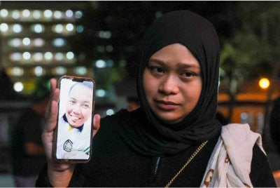 Nurkhaeryna menunjukkan gambar Allahyarham suaminya, Muhammad Faezuan Hakim Mohammad Bustaman, 28, dilaporkan maut ketika menjalani latihan kecemasan di perairan Terengganu-Pahang. Foto Bernama 