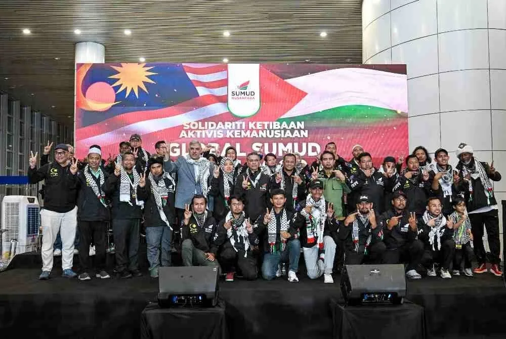 Menteri Besar Selangor Datuk Seri Amirudin Shari (tengah) bergambar bersama aktivis Global Sumud Flotilla 2.0 sejurus tiba di balai ketibaan Lapangan Antarabangsa Kuala Lumpur (KLIA) pada Ahad. Foto Bernama.
