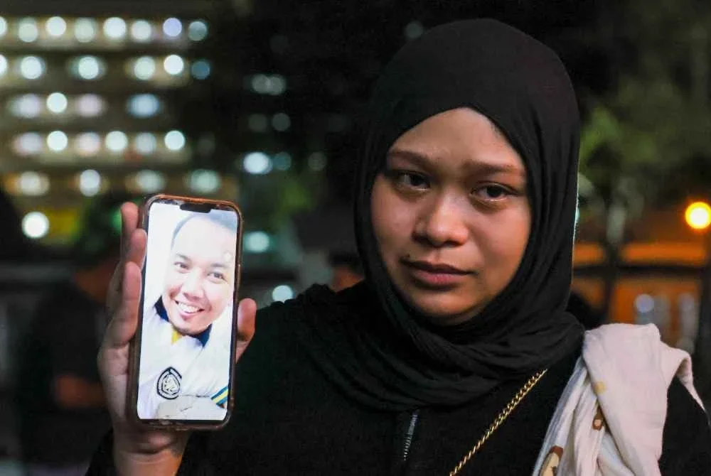 Nurkhaeryna Dhania Azreen menunjukkan gambar Allahyarham suaminya, Muhammad Faezuan Hakim dilaporkan maut dalam kemalangan yang dipercayai berpunca daripada tali bot yang terputus ketika menjalani latihan kecemasan di perairan Terengganu-Pahang, semasa ditemui di Jabatan Perubatan Forensik, Hospital Sultanah Nur Zahirah (HSNZ). Foto Bernama