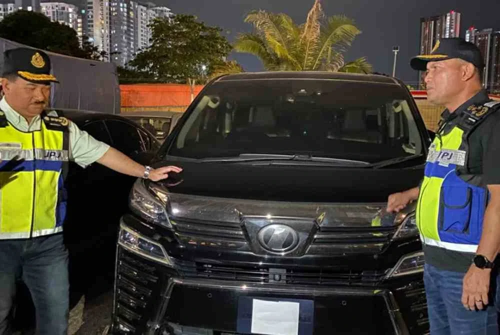 Jazmanie (kanan) melihat kenderaan jenis Toyota Vellfire milik bekas pemain bola sepak kebangsaan yang disita JPJ menerusi Op Luxury.