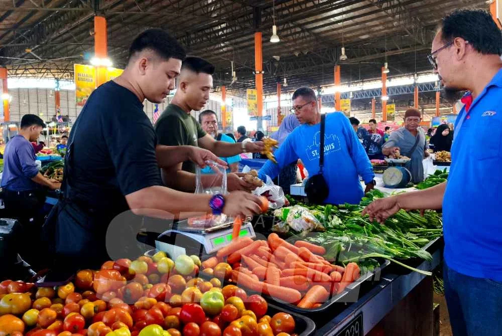 Peniaga di RTC Tunjong, Kota Bharu tidak menang tangan melayan pelanggan yang datang ke gerai bagi mendapatkan bekalan sayur untuk digunakan pada Aidiladha nanti. Foto:SINAR HARIAN/HAZELEN LIANA KAMARUDIN