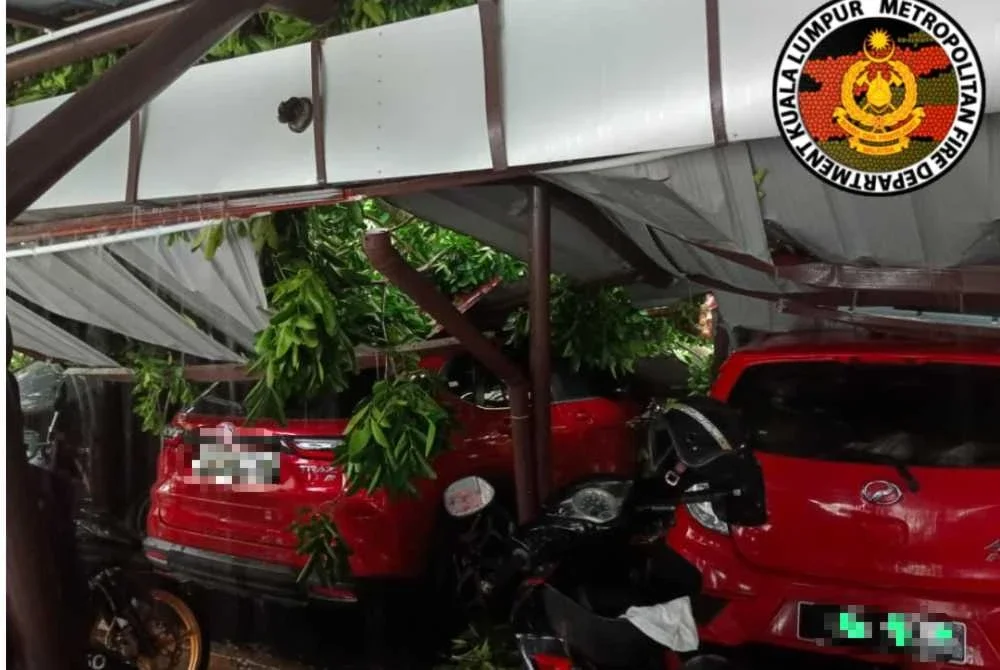 Kejadian di Institut Sosial Malaysia membabitkan sebatang pokok besar tumbang sehingga dahan pokok menghempap bumbung kawasan parkir kenderaan. Foto JBPM Kuala Lumpur
