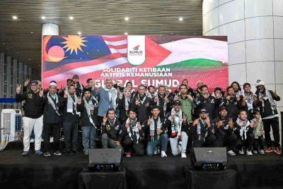 Menteri Besar Selangor Datuk Seri Amirudin Shari (tengah) bergambar bersama aktivis Global Sumud Flotilla 2.0 sejurus tiba di balai ketibaan Lapangan Antarabangsa Kuala Lumpur (KLIA) pada Ahad. Foto Bernama. 