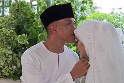 Arif Aiman mengucup dahi Nurul Aliah Natasha selepas sah bergelar suami isteri. - Foto media sosial