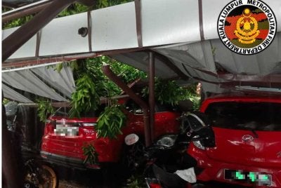 Kejadian di Institut Sosial Malaysia membabitkan sebatang pokok besar tumbang sehingga dahan pokok menghempap bumbung kawasan parkir kenderaan. Foto JBPM Kuala Lumpur