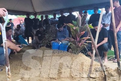 Waris kepada Allahyarham Nik Muhammad Hafifi mendengar talkin selepas selesai pengebumian di Tanah Perkuburan Islam Setali pada Isnin. 