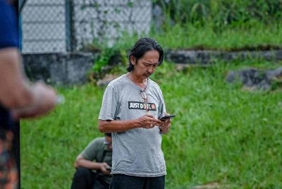 Haszman Othman, 61, hadir di Pusat Kawalan Tempat Kejadian (PKTK) untuk mengikuti perkembangan insiden kehilangan Isterinya Jaslinda Saludin, 49, di Surau At Taqwa, Kuarters TNB Batu 7, Kuala Woh pada Isnin. Foto Bernama.