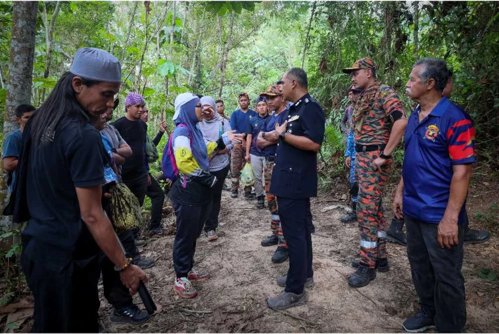 Ketua Polis Daerah Hulu Selangor, Asisten Komisioner Ibrahim Husin (tiga dari kanan) berjumpa dengan ibu mangsa remaja hilang (dua dari kiri) ketika beliau bersama pasukan keselamatan meninjau sekitar lokasi operasi mencari dan menyelamat (SAR) di Bukit Changkat Asa di Tanjong Malim. Foto Bernama