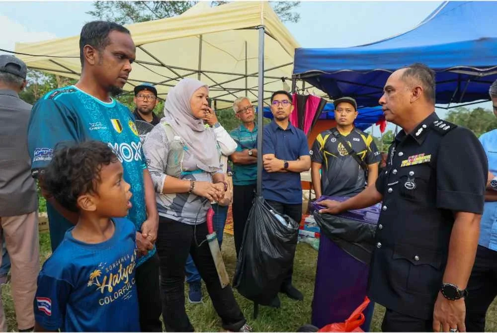 Ketua Polis Daerah Hulu Selangor, Asisten Komisioner Ibrahim Husin (kanan) berjumpa dengan bapa mangsa remaja hilang Azizul Abdul Aziz, 48, (kiri) selepas beliau bersama pasukan keselamatan meninjau sekitar lokasi operasi mencari dan menyelamat (SAR) di Bukit Changkat Asa di Tanjong Malim. Foto Bernama