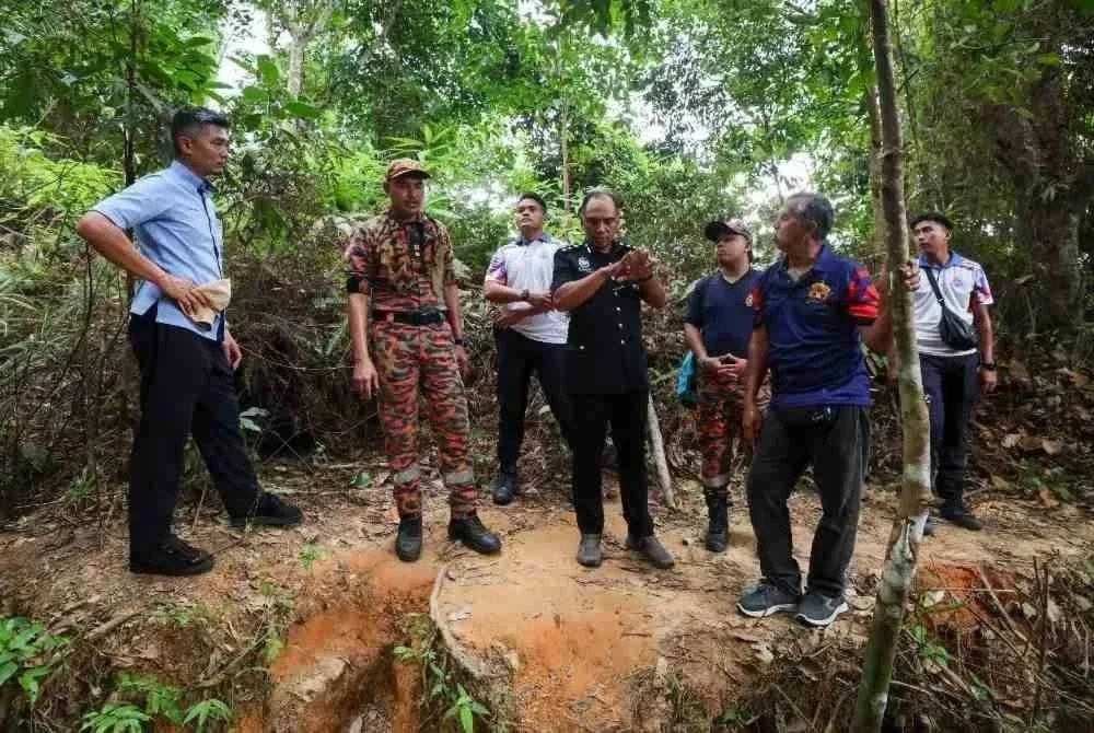 Ketua Polis Daerah Hulu Selangor, ACP Ibrahim Husin (tengah) bersama pasukan keselamatan meninjau sekitar lokasi operasi mencari dan menyelamat (SAR) di Bukit Changkat Asa di Tanjong Malim hari ini. Nur Izzati Humaira Azizul, 19, dipercayai tersesat pada 10.50 pagi Sabtu lepas ketika menuruni bukit bersama-sama keluarganya selepas mengambil keputusan untuk berjalan sendirian supaya sampai lebih awal kerana berasa panas dan penat. Foto Bernama. 