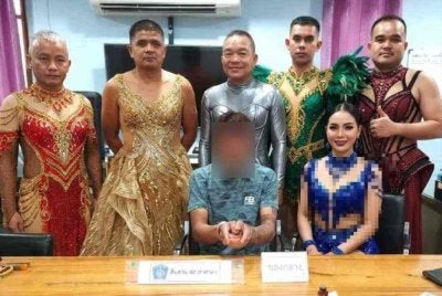 Kesemua anggota polis berkenaan yang mengenakan kostum penari berjaya menangkap Mekha (duduk, tengah). Foto: FB Globe - Bangkok's News Lifestyle