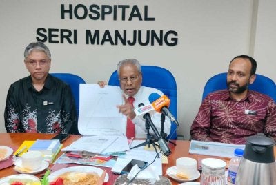 Sivesan (tengah) menunjukkan carta yang menjelaskan bahawa Hospital Seri Manjung tidak mempunyai sebarang perkaitan dengan isu pertikaian kerja membabitkan pekerja pembersihan di hospital berkenaan.