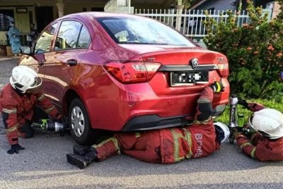 Anggota bomba membantu mengeluarkan mangsa yang tersepit di bawah kereta jenis Proton Saga. Foto JBPM Selangor