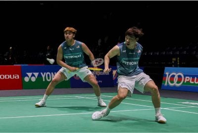 Beregu lelaki negara Kang Khai Xing (kiri) dan Aaron Tai mara ke suku akhir Terbuka Singapura. Foto Bernama