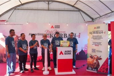 Tengku Ahmad Badli (tiga dari kanan) melakukan gimik pelancaran Akaun Simpanan AGROKorban-i di Agrobank Tanjong Karang di sini pada Khamis.