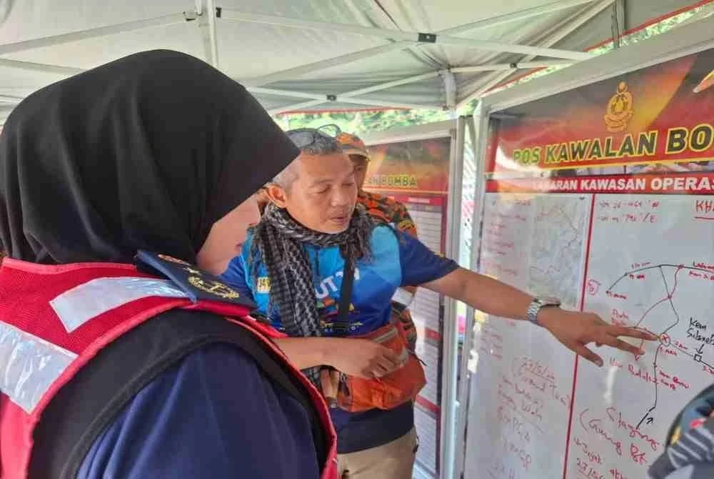 Muzafar berkongsi pandangan bersama Pengarah Jabatan Bomba dan Penyelamat Malaysia (JBPM) Perak, Datuk Sayani Saidon mengenai operasi SAR pendaki wanita hilang, Jaslinda Saludin, 49, di Pusat Kawalan Bomba di Surau At-Taqwa, Stesen Janakuasa Sultan Idris II Woh, Tapah.