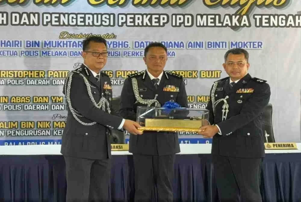 Dzulkhairi (tengah) menyaksikan majlis serah terima tugas Ketua Polis Melaka Tengah oleh SAC Christopher Patit (kiri) kepada Superinden Halim Abas.
