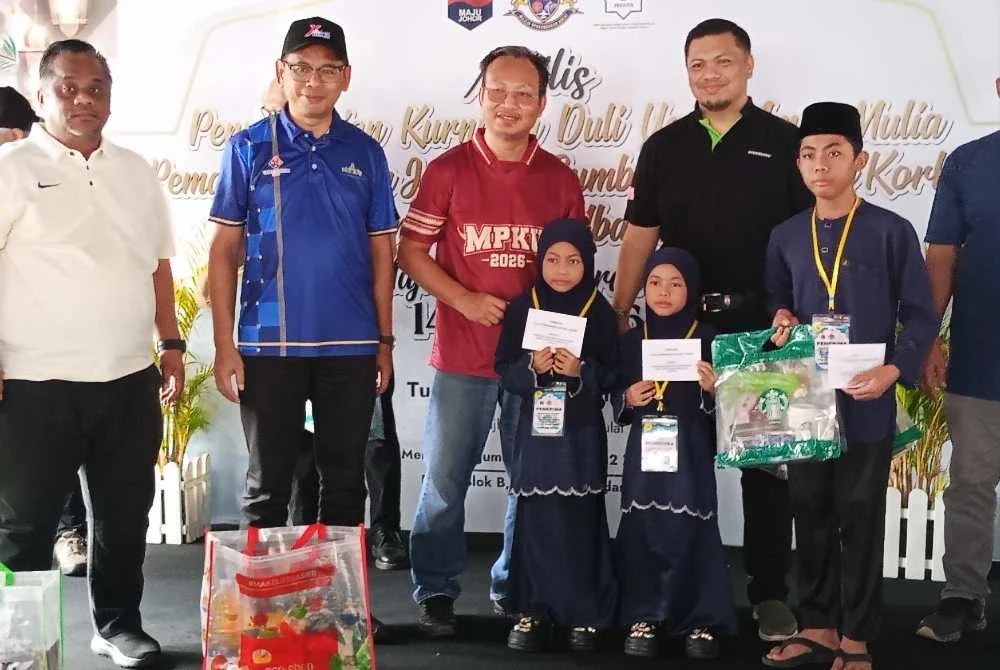 Mohd Hafiz (dua dari kiri) menyerahkan kurniaan Pemangku Sultan Johor kepada anak-anak yatim di daerah Kulai di Bangunan MPKu pada Jumaat.