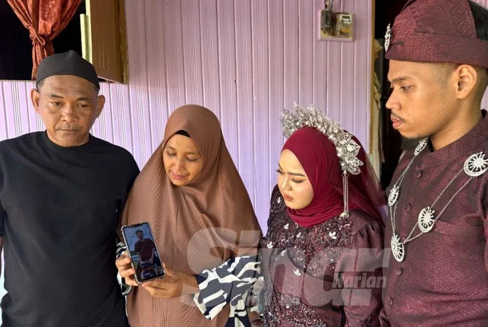Ahli keluarga melihat gambar Allahyarham. Foto Adila Sharini Wahid