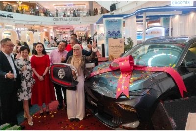 Azira (kanan) ketika diumumkan pemenang hadiah utama sempena sambutan ulangtahun ke-10 Aman Central pada Jumaat.