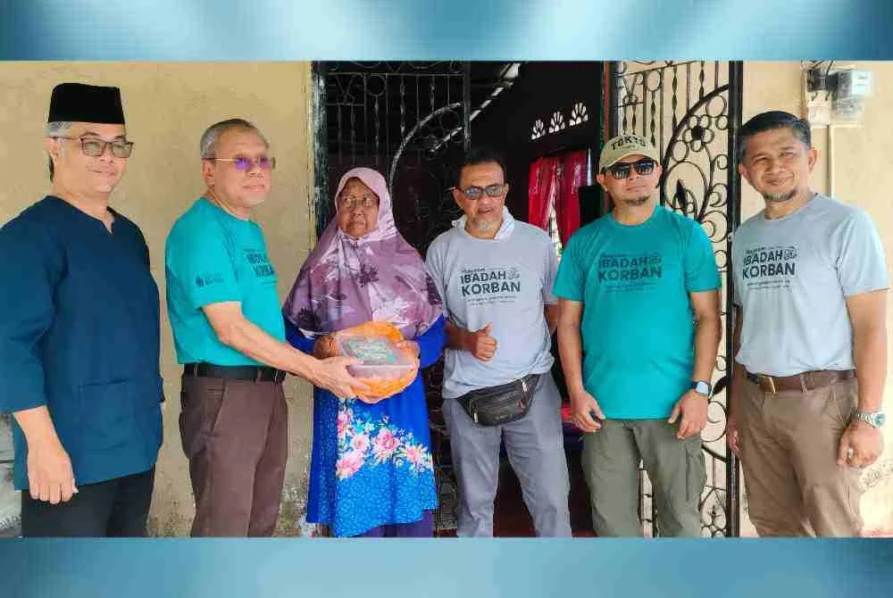 Mohd Shaiful (dua dari kiri) menyerahkan daging korban kepada penerima sempena Program Ibadah Korban KAM JPA bersama komuniti Kampung Kotak Bharu sempena Sambutan Hari Raya Aidiladha, pada Sabtu.