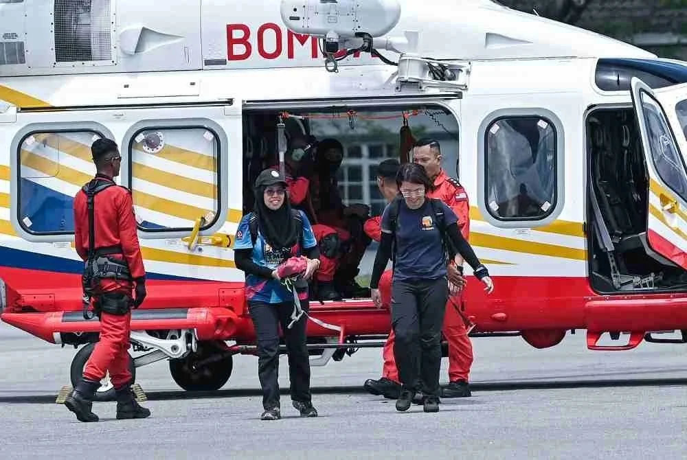 Pegawai Hutan Daerah Tapah, Norliza Md, (kiri) bersama Persatuan Badan Bukan Kerajaan (NGO) PELINDUNG, Liang Neo Song Wee (kanan) membawa ‘footage camera trap’ yang diletakkan di kawasan dipercayai tempat mangsa pendaki wanita yang hilang Jaslinda Saludin, 49 ketika ditemui di Pusat Kawalan Hadapan (PKH) Bomba di Batalion 3 PGA, Bidor di sini hari ini. Foto Bernama.