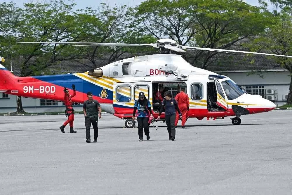 Pegawai Hutan Daerah Tapah, Norliza Md, (dua kanan) bersama Persatuan Badan Bukan Kerajaan (NGO) PELINDUNG, Liang Neo Song Wee (kanan) membawa ‘footage camera trap’ yang diletakkan di kawasan dipercayai tempat mangsa pendaki wanita yang hilang Jaslinda Saludin, 49 ketika ditemui di Pusat Kawalan Hadapan (PKH) Bomba di Batalion 3 PGA, Bidor di sini hari ini. Foto Bernama.