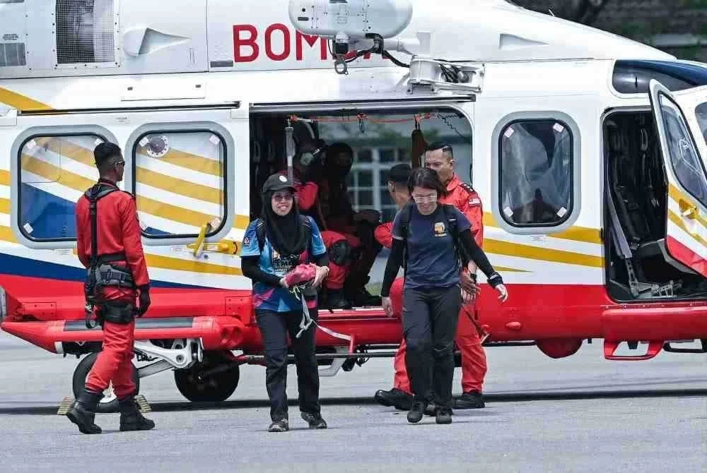 Pegawai Hutan Daerah Tapah, Norliza Md, (kiri) bersama Persatuan Badan Bukan Kerajaan (NGO) PELINDUNG, Liang Neo Song Wee (kanan) membawa ‘footage camera trap’ yang diletakkan di kawasan dipercayai tempat mangsa pendaki wanita yang hilang Jaslinda Saludin, 49 ketika ditemui di Pusat Kawalan Hadapan (PKH) Bomba di Batalion 3 PGA, Bidor di sini hari ini. Foto Bernama.