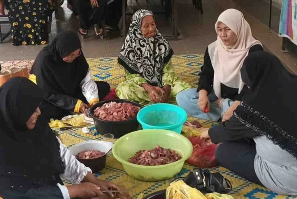 Suasana gotong-royong di Rumah Ngaji Teluk Muroh di sini yang mengadakan ibadah korban pada Khamis.
