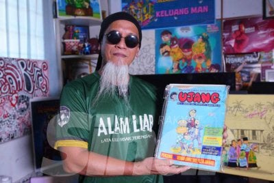Ujang menunjukkan majalah Ujang edisi pertama yang dikeluarkan pada Januari 1994. Foto Sinar Harian - MOHD HALIM ABDUL WAHID