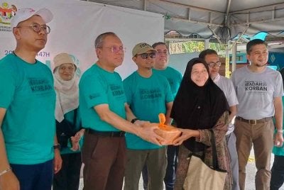 Mohd Shaiful (tiga dari kiri) menyerahkan daging korban sempena Program Ibadah Korban KAM JPA bersama komuniti Kampung Kota Bharu di Masjid Jamek Kampung Kota Bharu di kampar pada Sabtu.