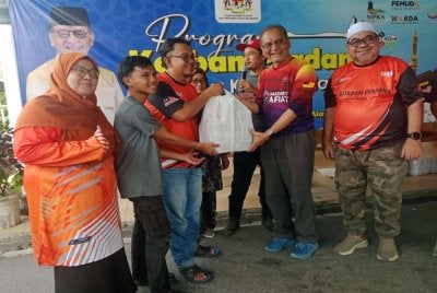 Dr Dzulkefly (dua dari kanan) mengagihkan daging korban kepada penerima pada Program Korban Perdana Parlimen Kuala Selangor di Dewan Komuniti Fasa 3, Bandar Puncak Alam di sini pada Sabtu.