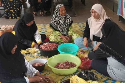 Suasana gotong-royong di Rumah Ngaji Teluk Muroh di sini yang mengadakan ibadah korban pada Khamis.