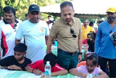 Vigneswaran (dua dari kanan) melihat kanak-kanak mewarna sempena Sambutan Hari Keluarga MIC sempena ulang tahun ke-80 parti itu di Taman DR Seenivasagam pada Ahad.
