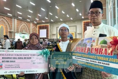 Muhammad Iqbal Danial (tengah) bersama ibu bapanya.