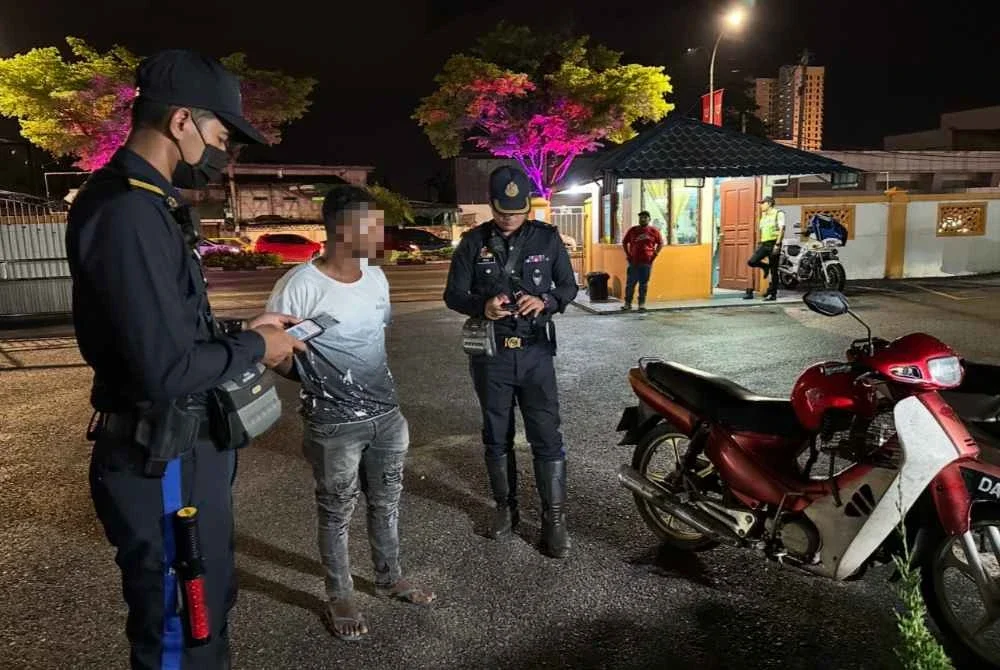 Pemeriksaan dilakukan terhadap pelarian Rohingya (tengah) yang menunggang motosikal.