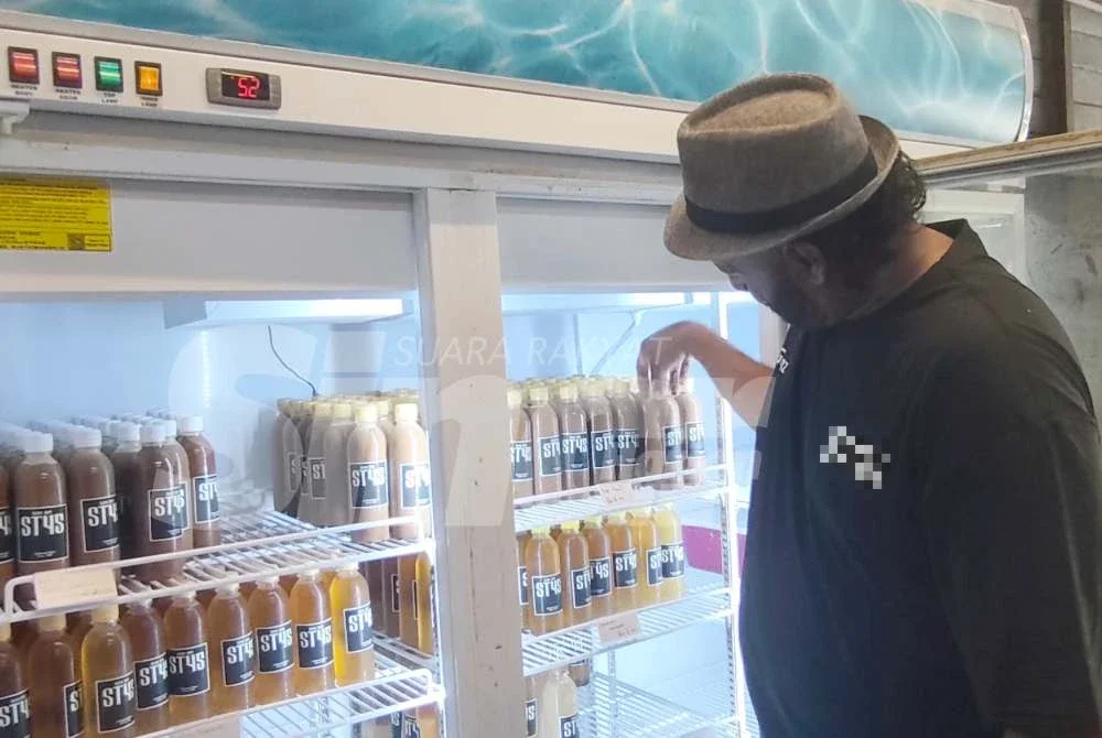 Abdul Ghani menyusun kopi yang dihasilkan di kedai miliknya.