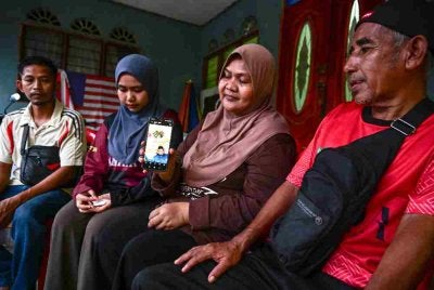 Nor Haida (dua dari kanan), bersama ahli keluarga menunjukkan gambar kenangan Aiman dan isterinya, Nor Azlin yang maut selepas terlibat dalam kemalangan membabitkan lima kenderaan berhampiran Penjara Simpang Renggam, Johor, ketika ditemui di kediamannya di Taman Setia, Bandar Al Muktafi Billah Shah hari ini. Foto: Bernama
