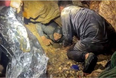 Pasukan penyelamat membantu mengeluarkan seorang daripada tujuh lelaki yang terperangkap di dalam gua berkenaan. Foto AFP