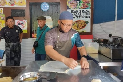 Mohd Tarmizi menebar roti canai pada program Jom Sarapan Pagi di kedai Ghodong Bukit Rangin Perdana di sini pada Selasa.