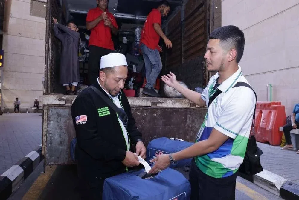 Mohd Ridzuan (kiri) bersama petugas menguruskan beg semasa proses CCI. - FOTO: TH