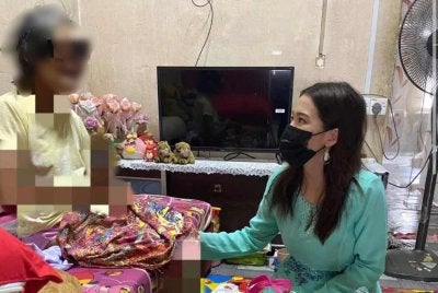 Marina menyantuni salah sorang penduduk ketika melakukan kerja-kerja membantu rakyat di lapangan. 