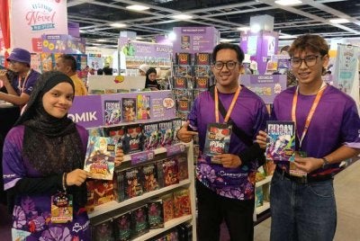 Muhamad Yusuf (dua dari kanan) menunjukkan komik baharu yang mendapat sambutan.